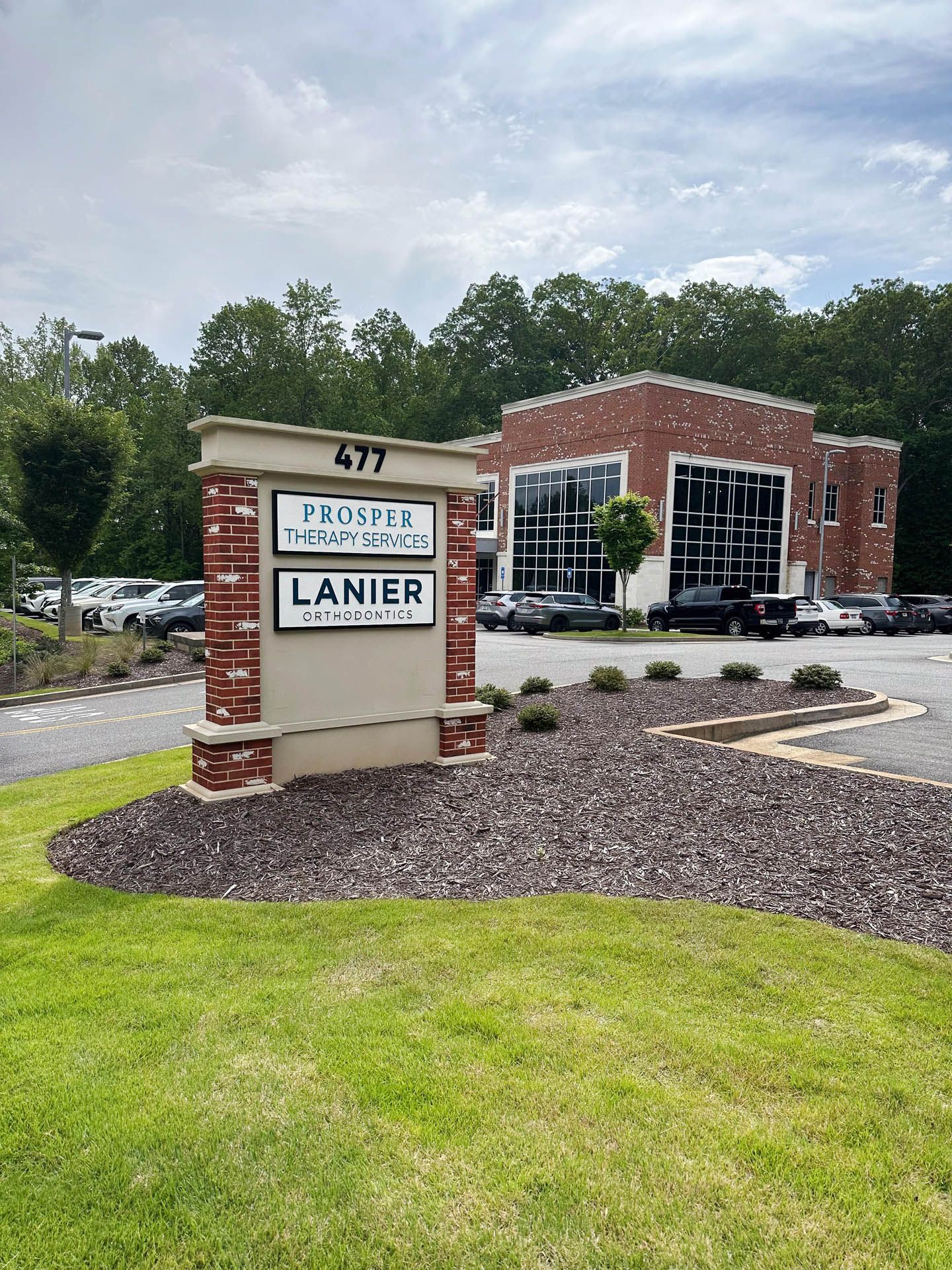 A large brick building with a sign in front of it.