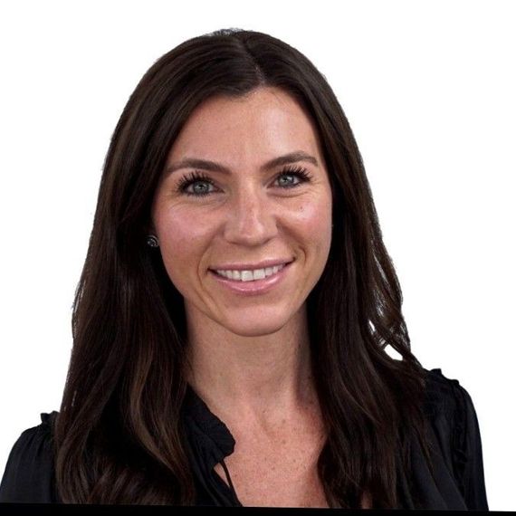 A man and a woman are sitting on a dock overlooking a lake.