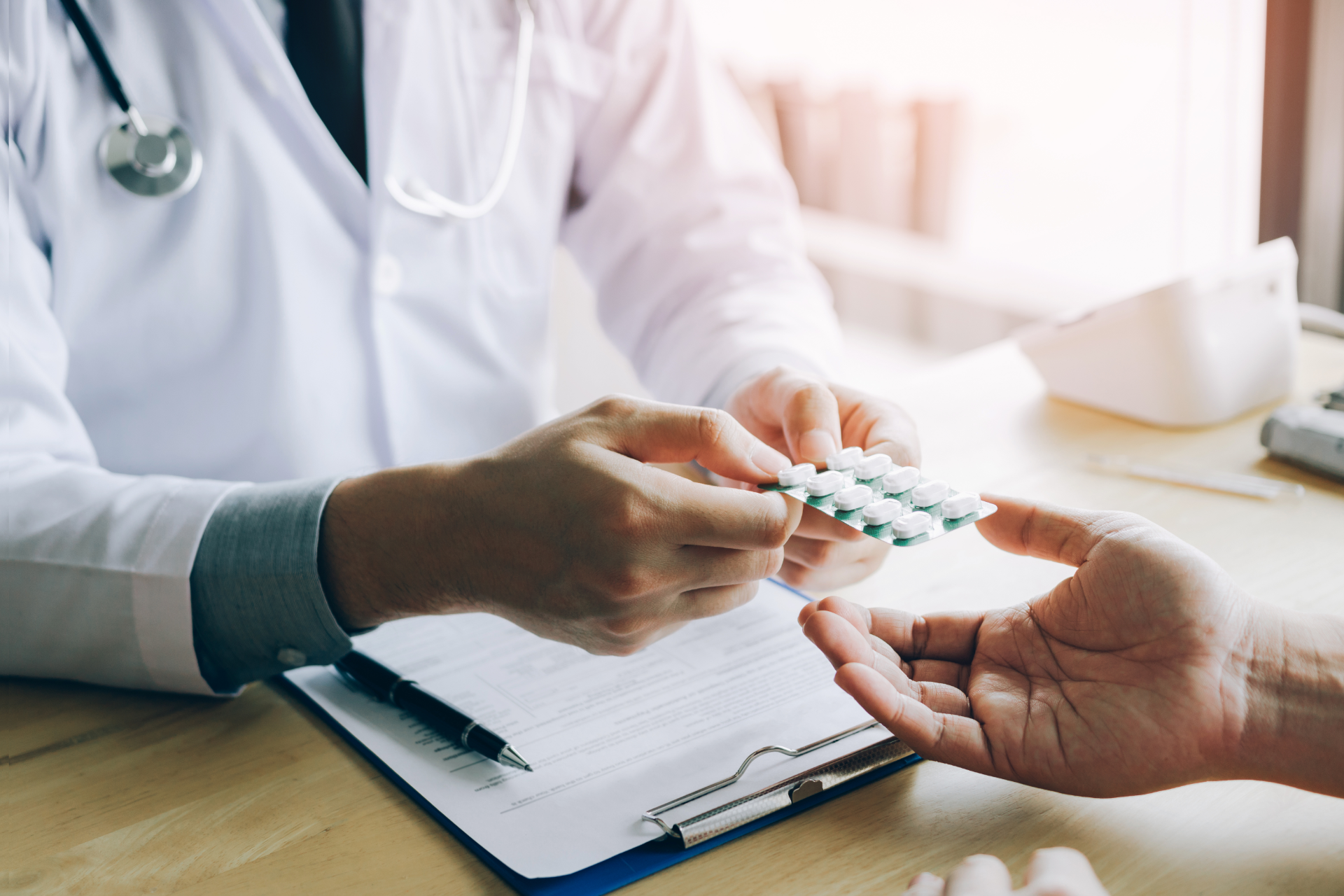 Doctor hands pills to a patient in a doctor's office.