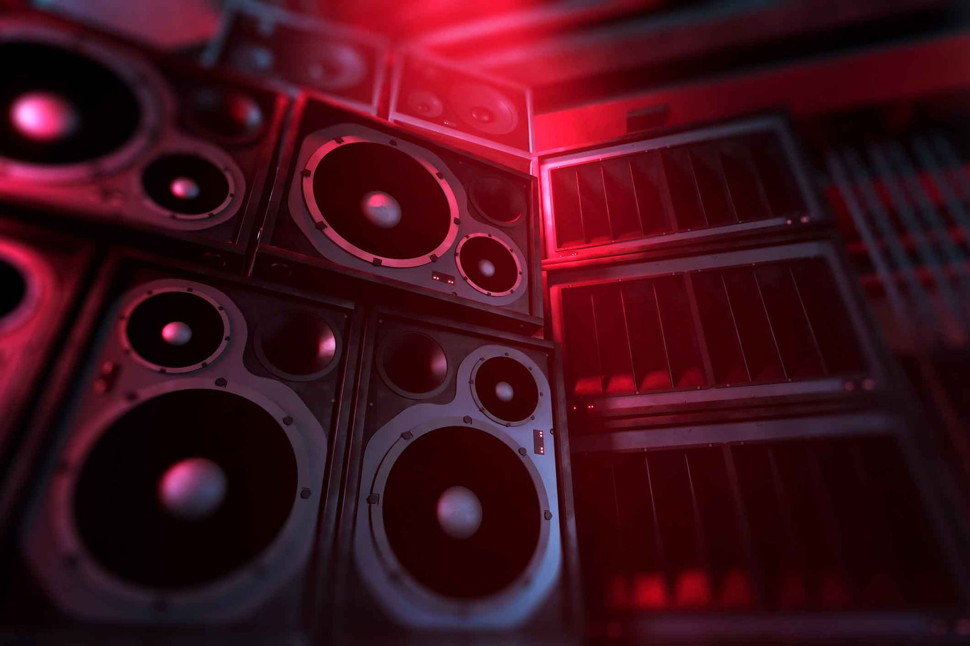 A bunch of speakers are stacked on top of each other in a dark room.