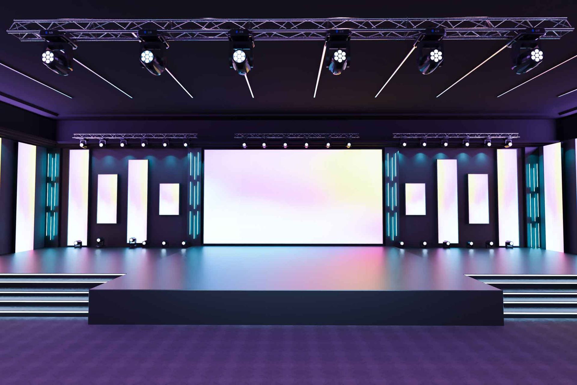 An empty stage with a large screen and a lot of lights.