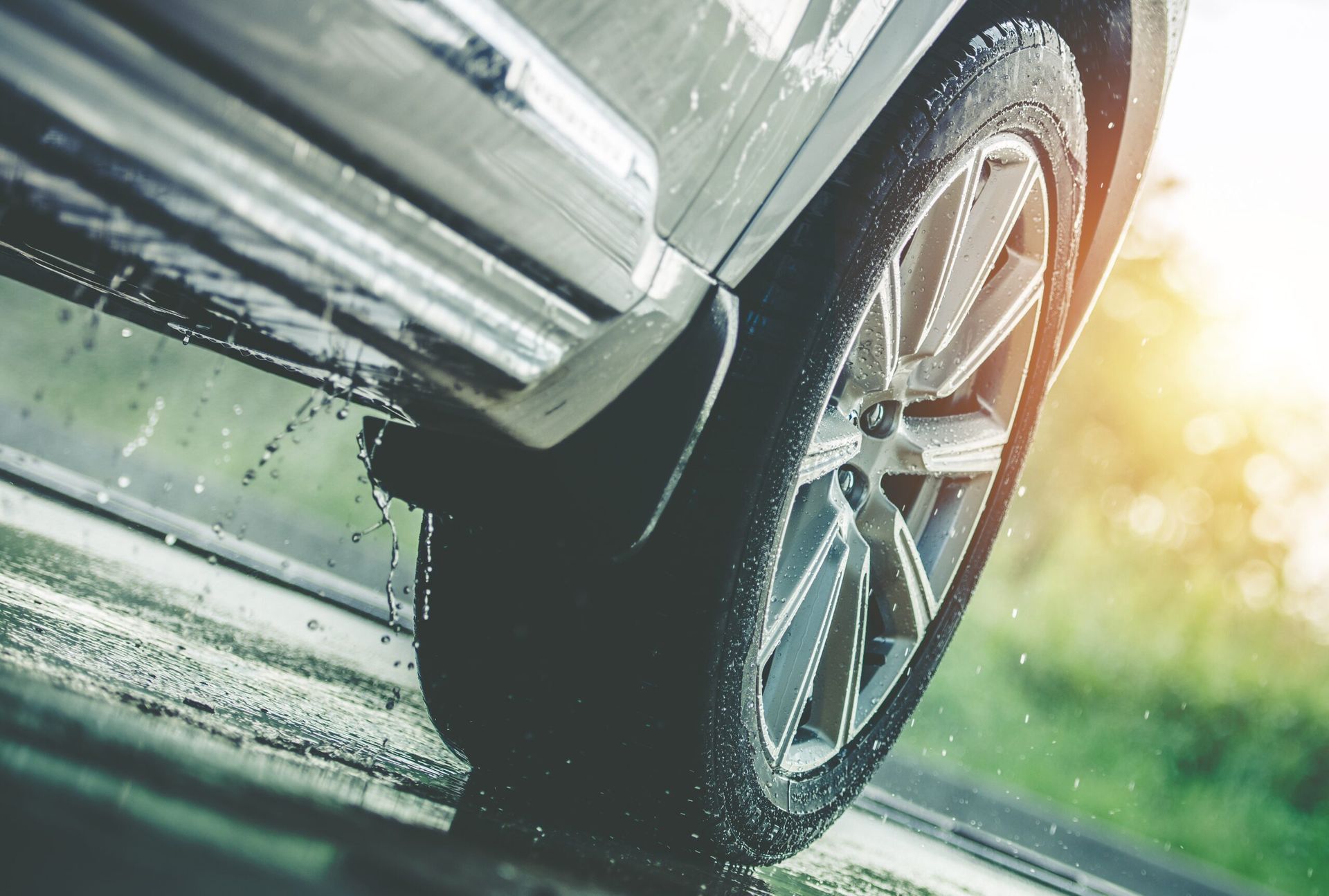 A car is driving down a wet road in the rain.