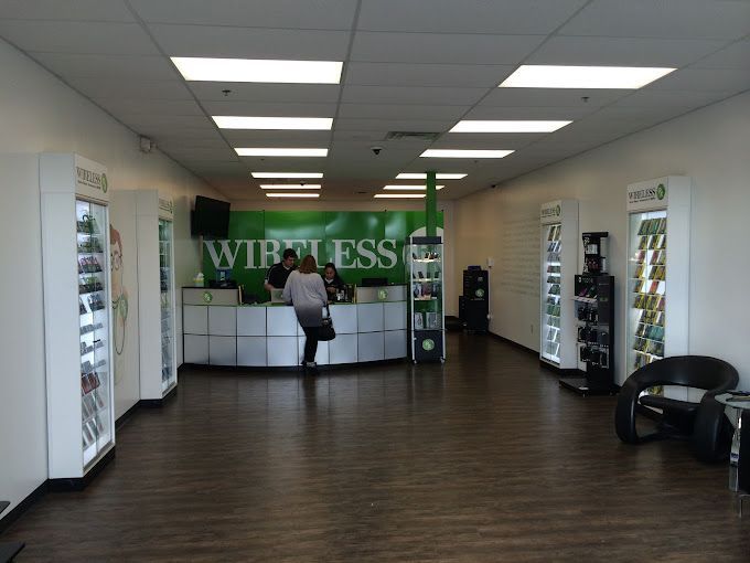 A woman is standing at a counter in a wireless store