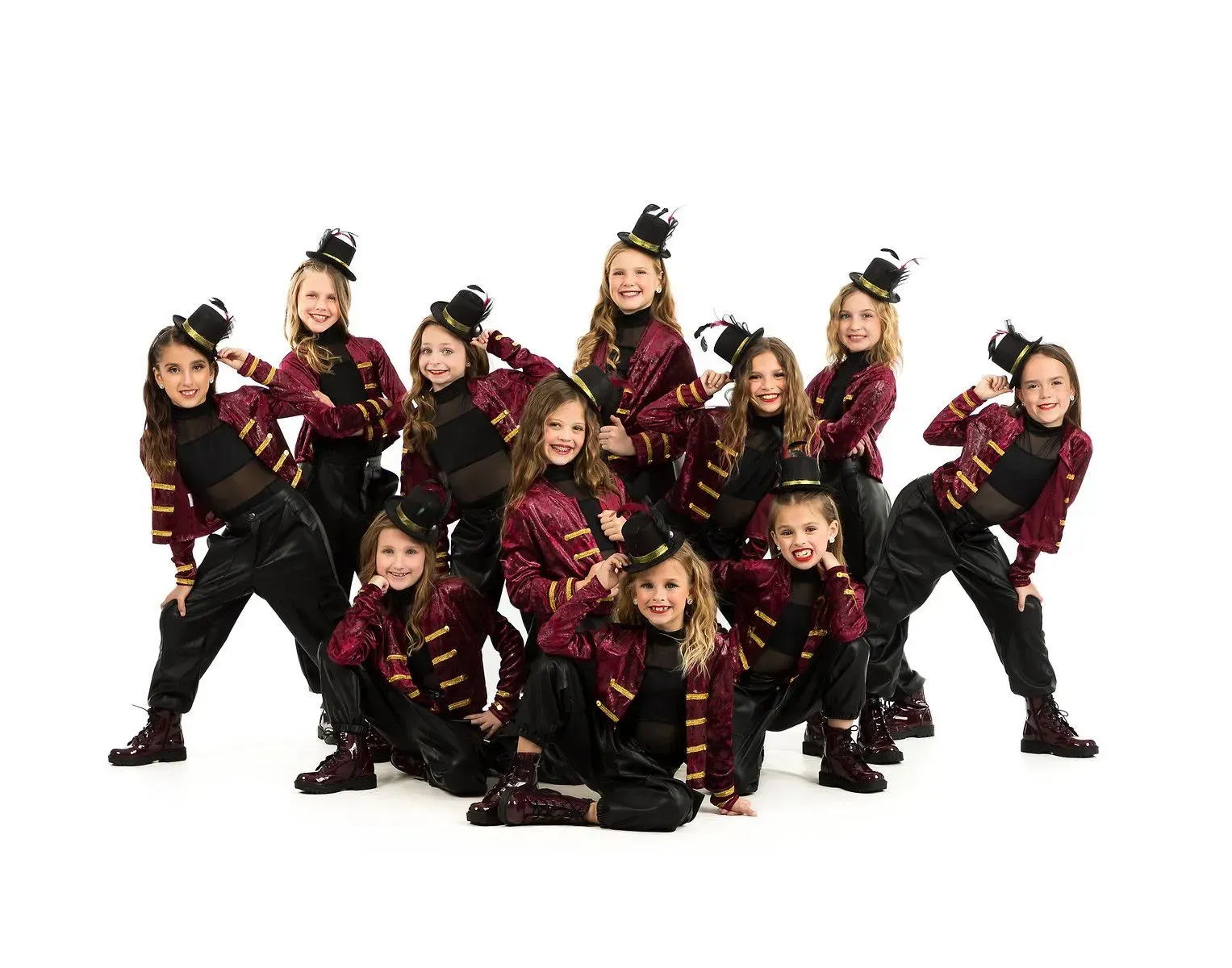 A group of young girls in top hats are posing for a picture.