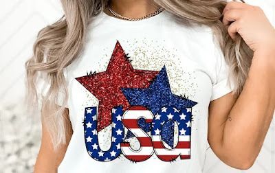 A woman is wearing a white t-shirt with the word usa and stars on it.