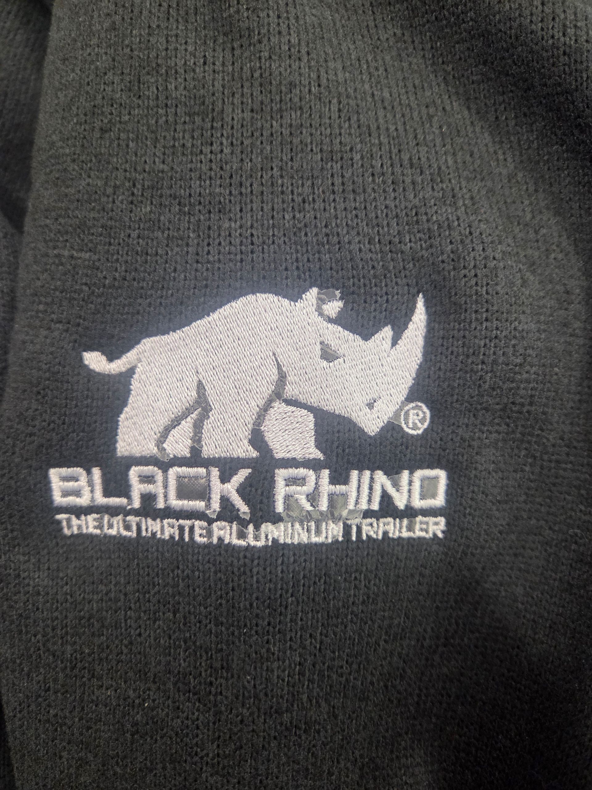 Black Rhino logo embroidered on black fabric: a rhino in silver and the words 