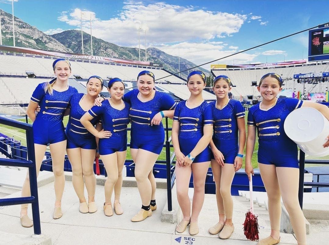 A group of young girls are posing for a picture in a stadium.
