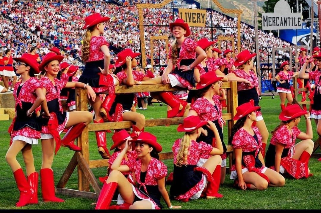 A group of cheerleaders wearing cowboy hats and boots