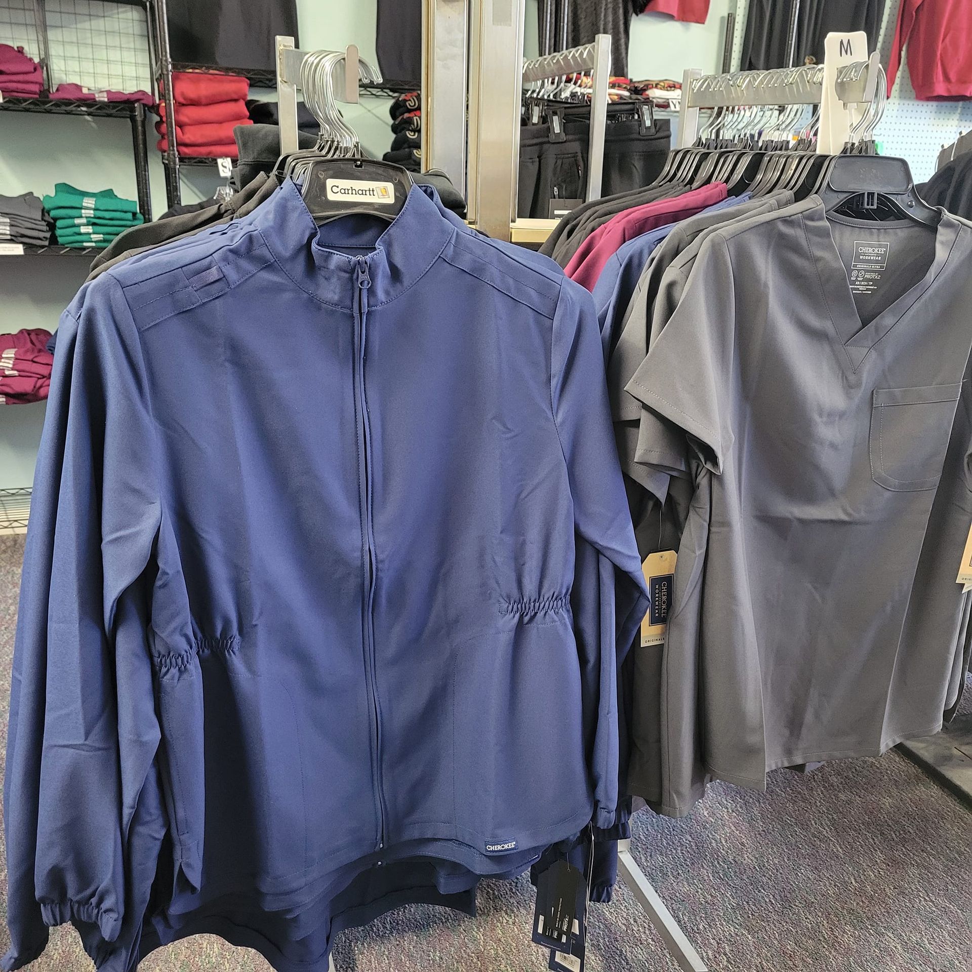 A blue jacket is hanging on a rack in a store