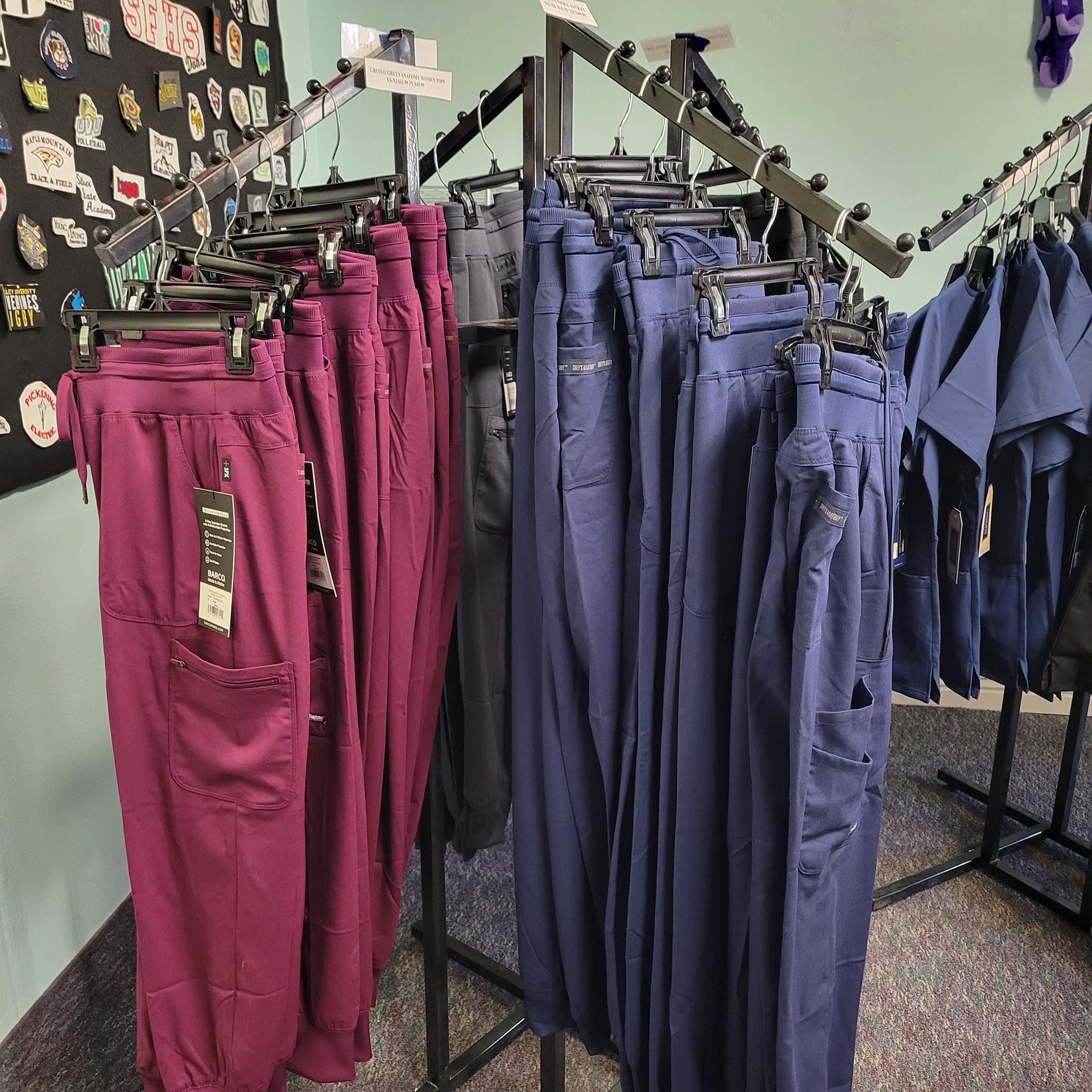 A bunch of scrubs are hanging on racks in a store
