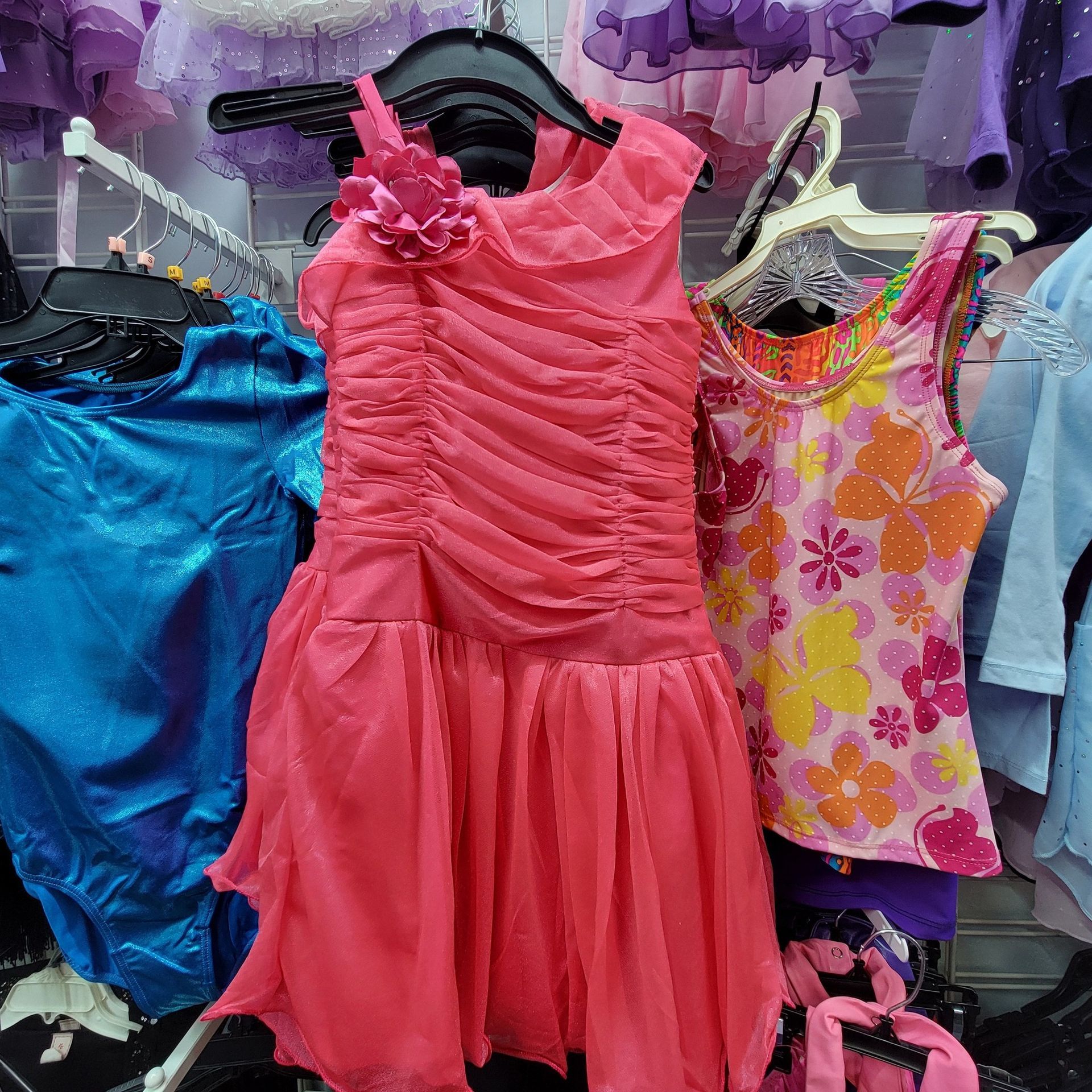 A pink dress is hanging on a rack in a store