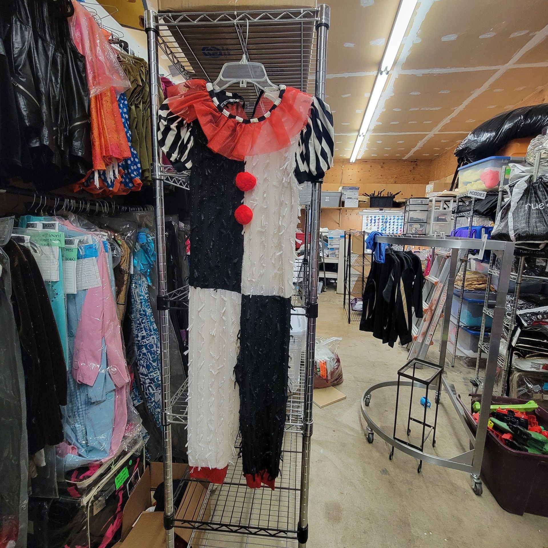 A clown costume is hanging on a rack in a store