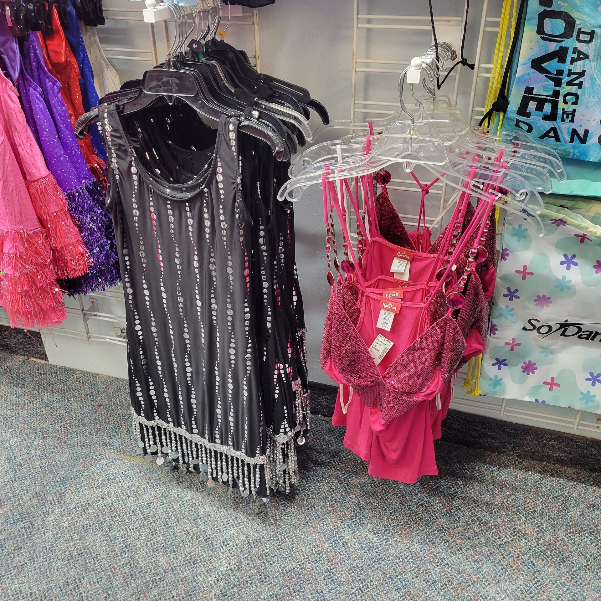 A bunch of clothes are hanging on a rack in a store