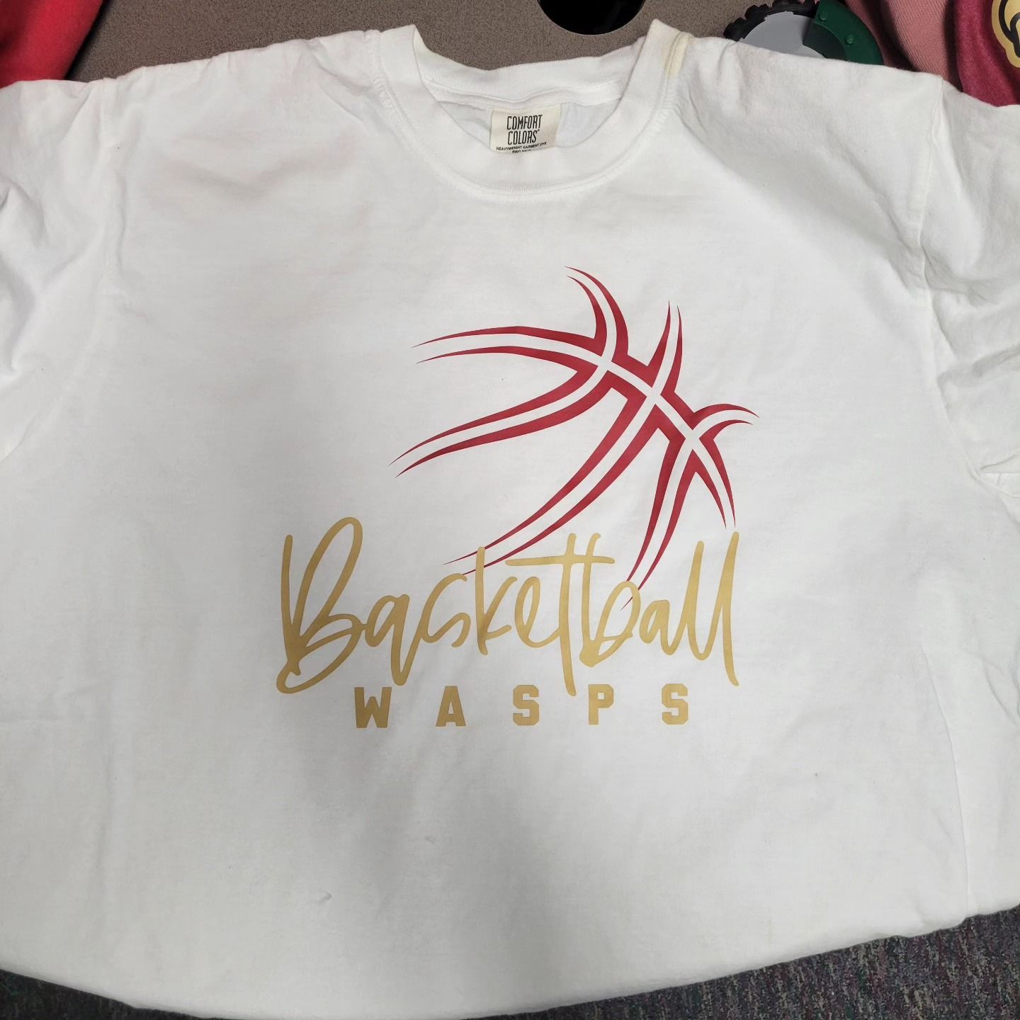 A white basketball wasps shirt with a red basketball on it