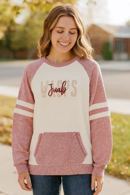 Woman smiling, wearing a pink and cream sweatshirt with 