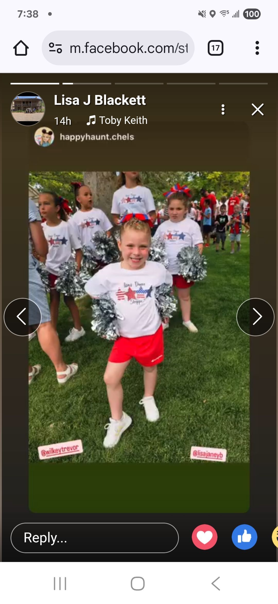 Young cheerleaders in red and white uniforms pose on a grassy field with silver pom-poms.