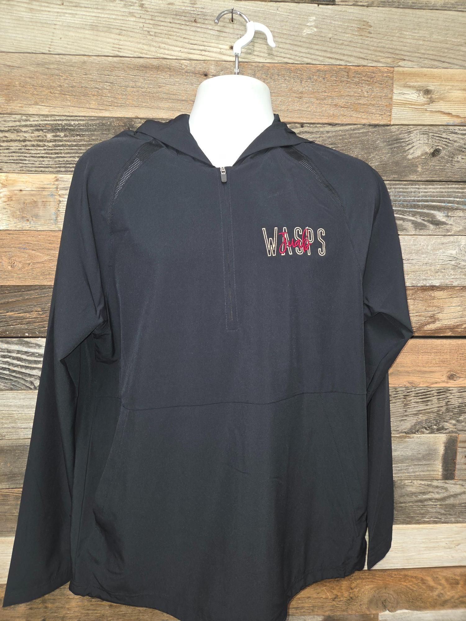 Black hooded jacket with a zipper, displayed on a mannequin.  The logo is on the left chest, with a wooden plank background.