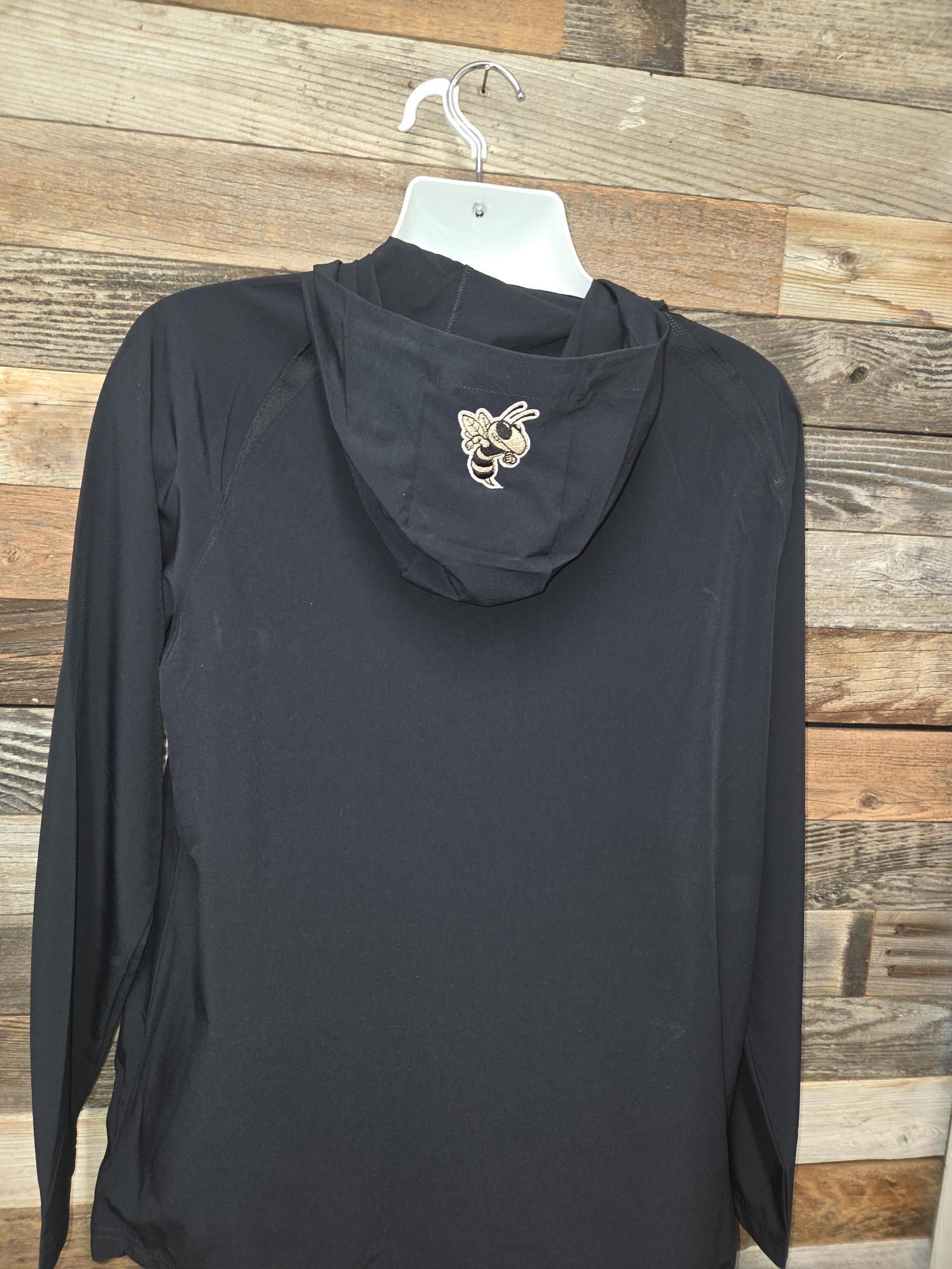 Black hooded long-sleeved shirt hanging against a weathered wood background. Gold design on the hood.