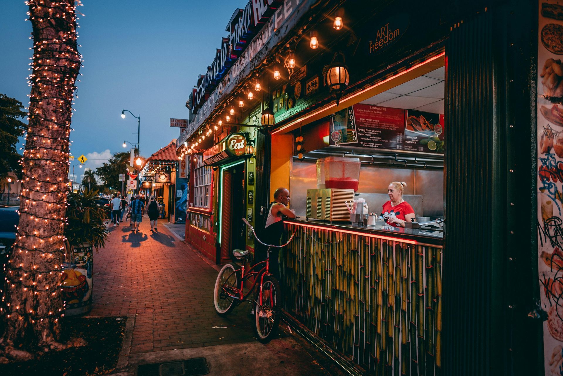 A woman is riding a bike in front of a restaurant.