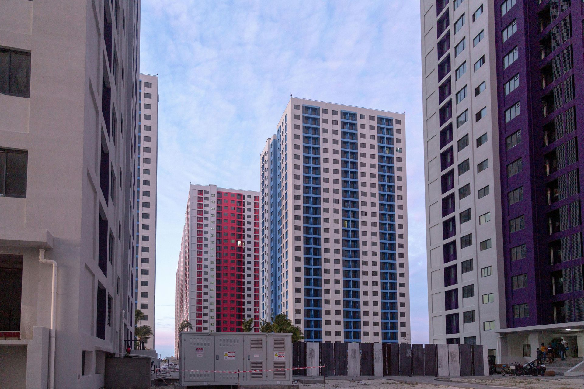 A row of tall buildings with red white and blue windows
