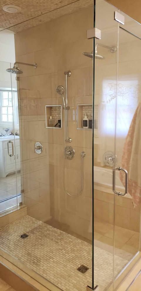 A bathroom with a walk in shower and a bathtub.