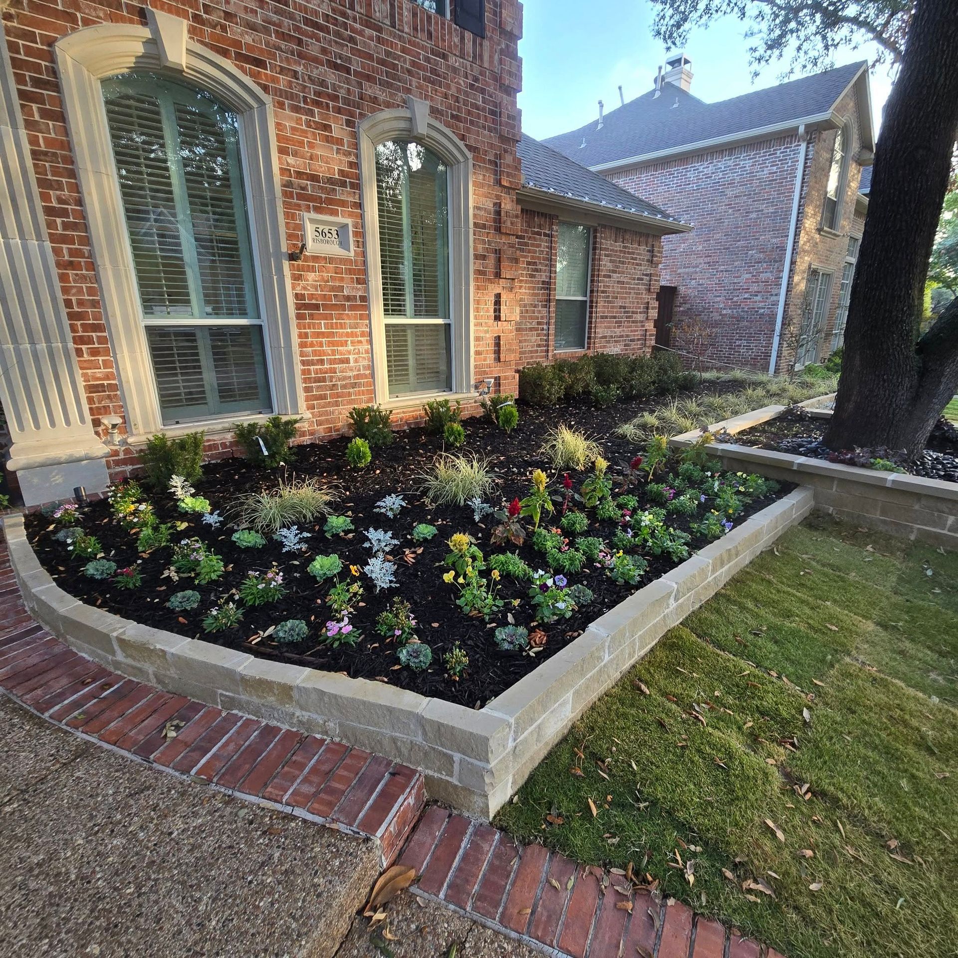 A brick house with a garden in front of it.