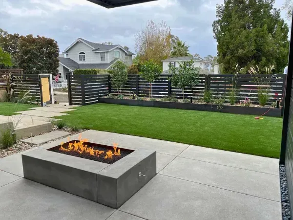 There is a fire pit in the middle of the backyard.