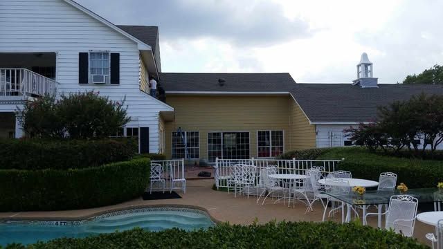 A large white house with a swimming pool in front of it