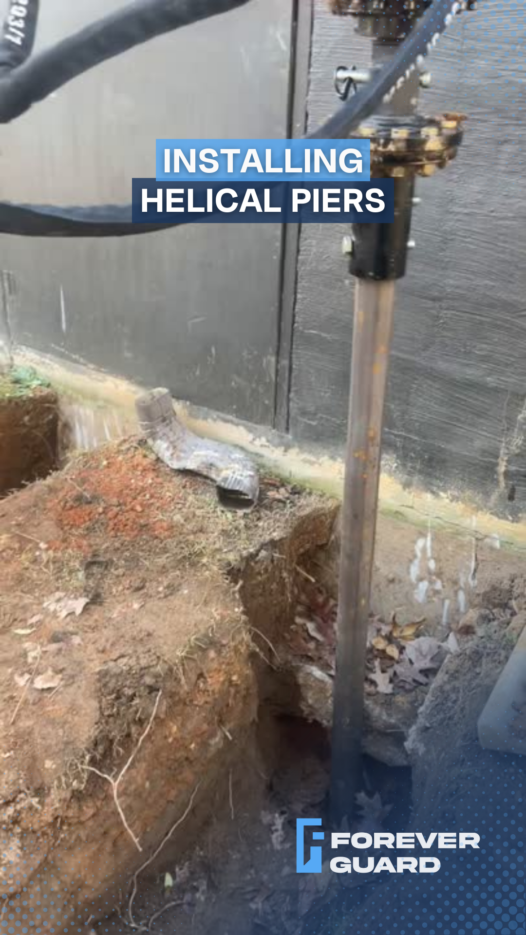 Installing a helical pier near a building foundation. A machine drills into the soil.
