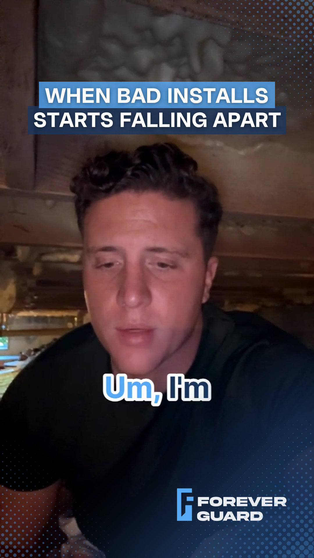 Man in dark shirt speaking, sitting under a structure. Text: