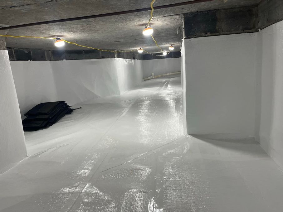 White interior space with white walls and floor; overhead lights, dark items on the left.