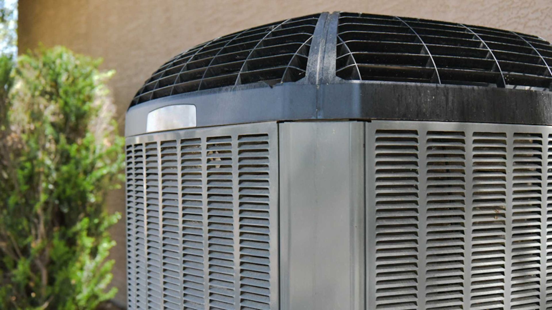 A large air conditioner is sitting on the side of a building.
