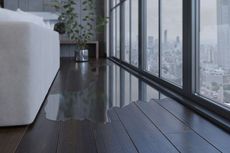 Water damage on dark wood floor near window with city view, near white sofa and plant.
