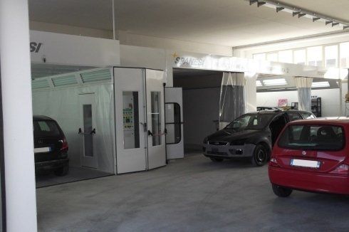 auto dentro l'autocarrozzeria in attesa di essere riparate