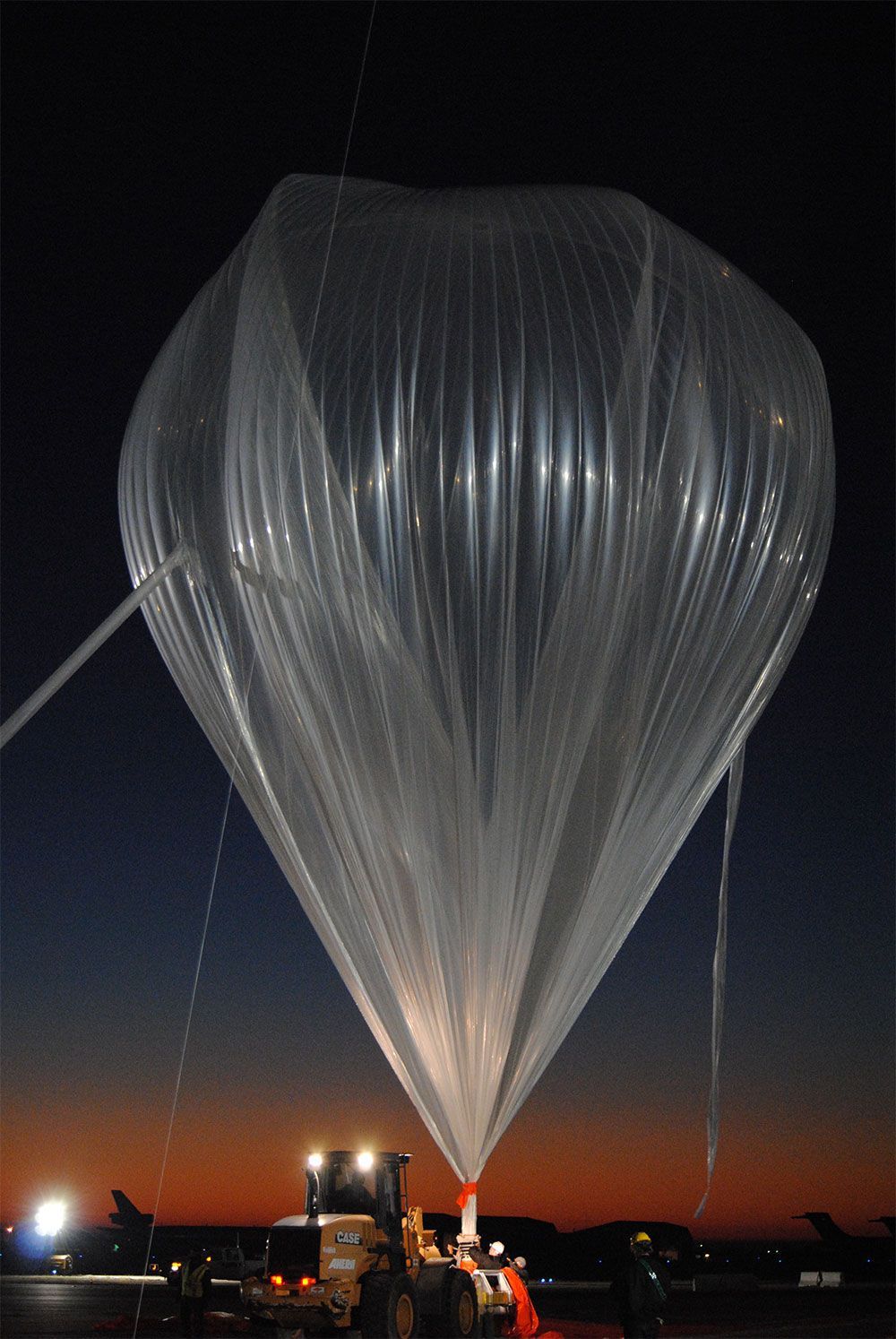A hot air balloon is being inflated at night