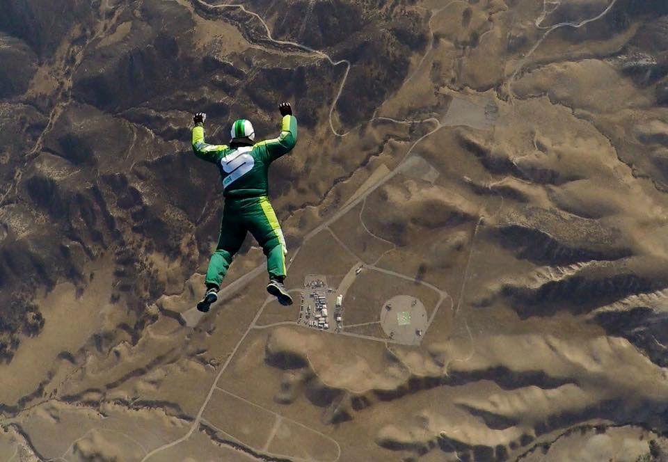 A man in a green suit is flying through the air