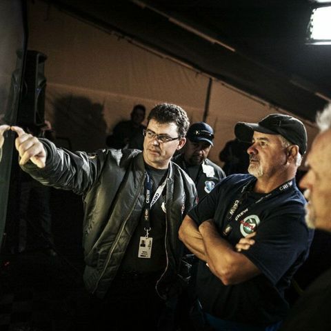 A man in a black jacket is pointing at something