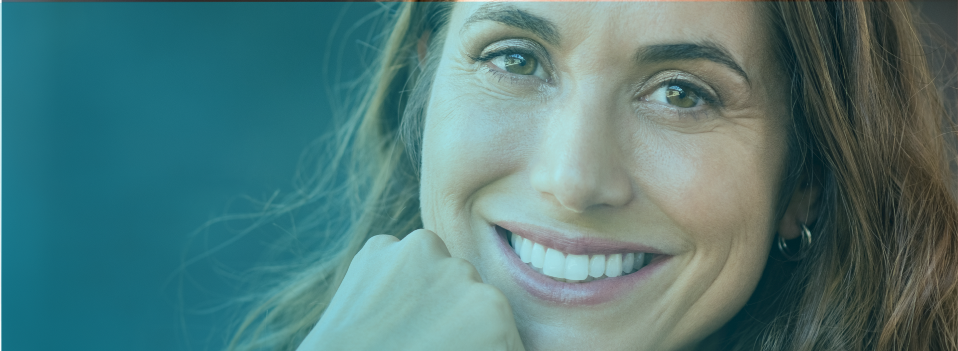 Portrait of a smiling woman with short blonde hair, displaying a confident, healthy smile with shiny teeth, the result of successful dental implants. She is wearing a light pink blouse and the background is dark blue, highlighting her happy, rejuvenated expression.