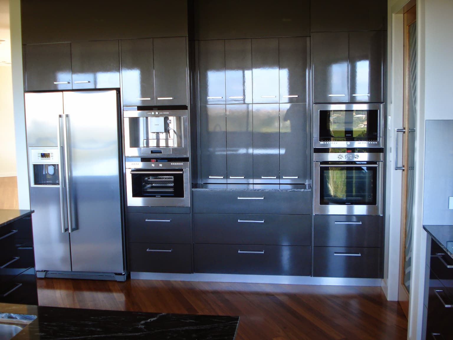 A Large Kitchen with Stainless Steel Appliances and A Large Island — Grant Wannan Plumbing in Wollongbar, NSW