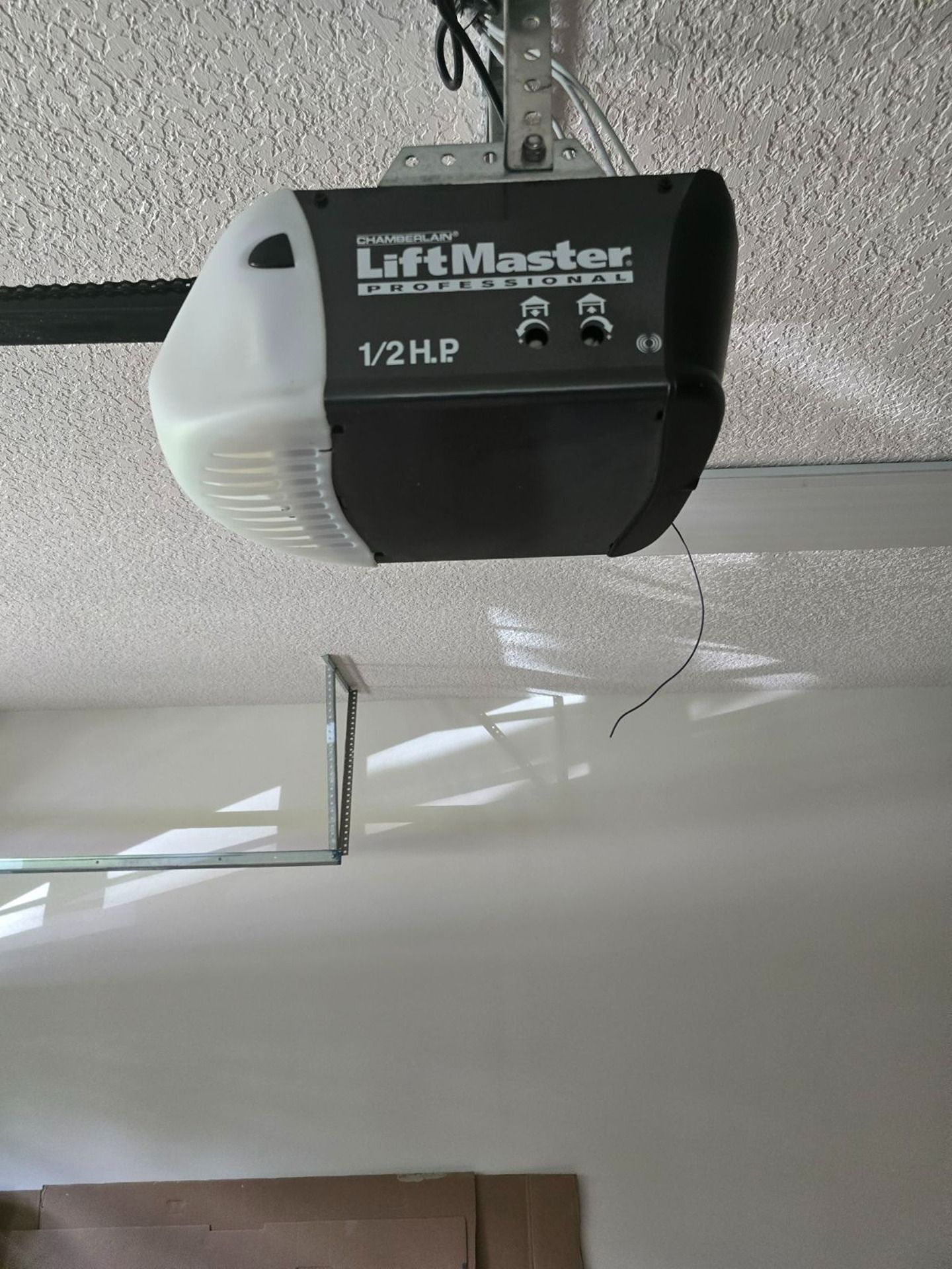 A LiftMaster 1/2 HP garage door opener motor unit mounted on a textured ceiling.