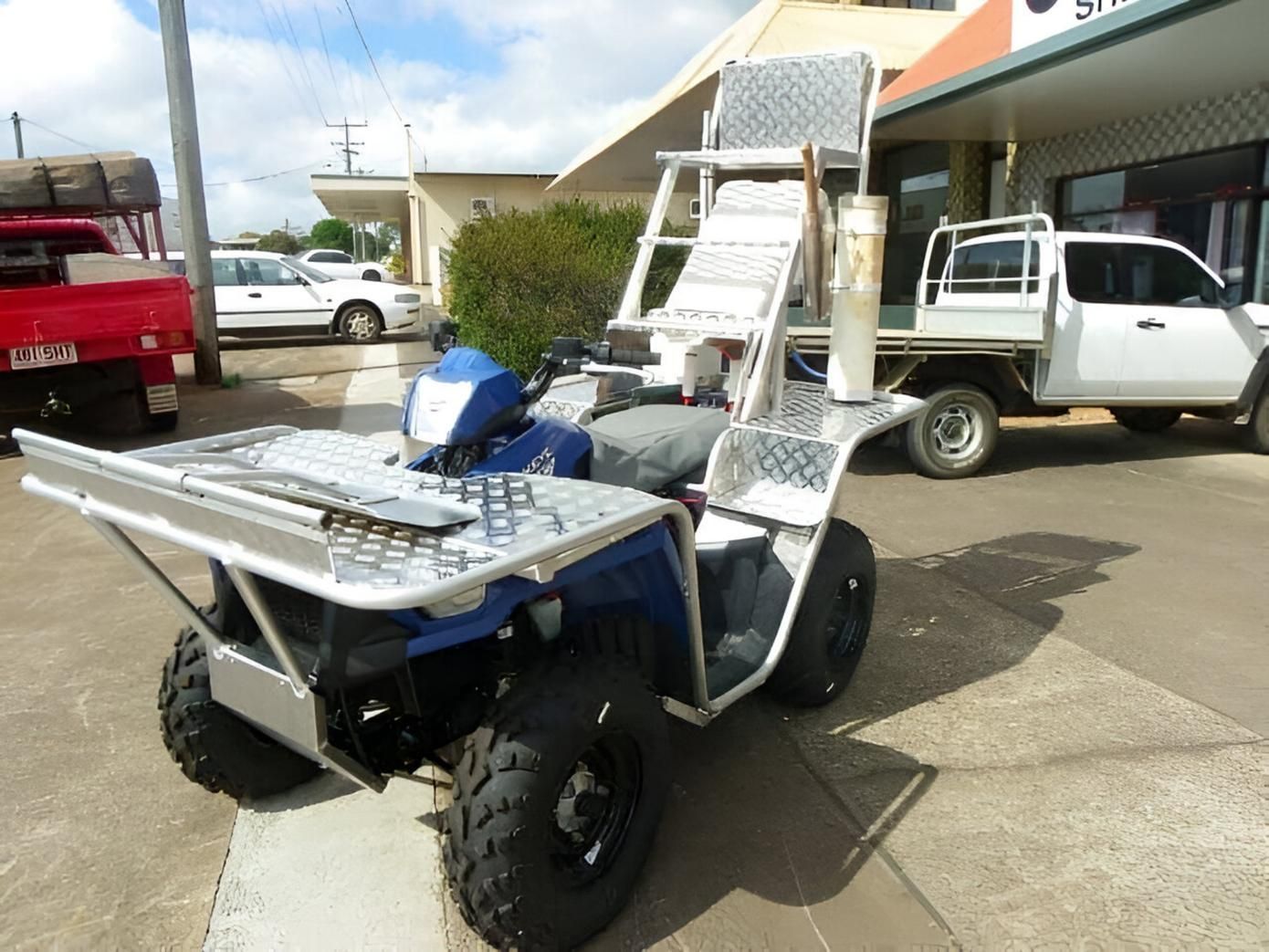 A Blue ATV is Parked Next to a White Truck — Eclipse Fabrication in Atherton, QLD