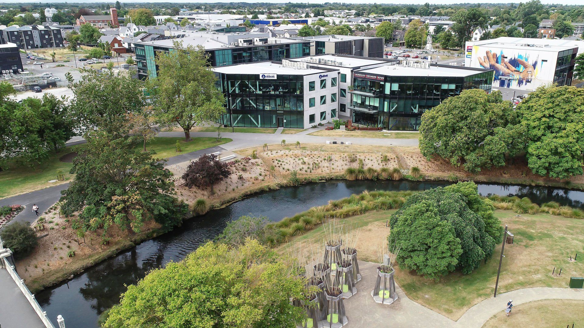 An aerial view of a park with a large building in the background