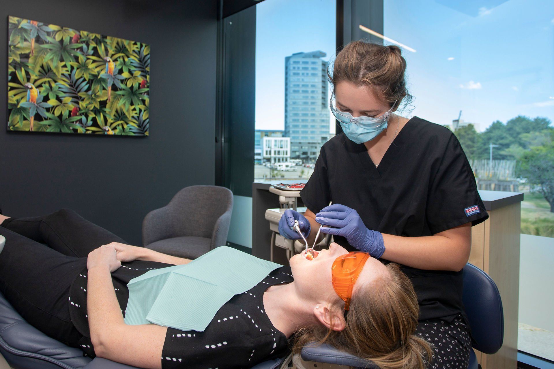 A woman is getting her teeth examined by a dentist