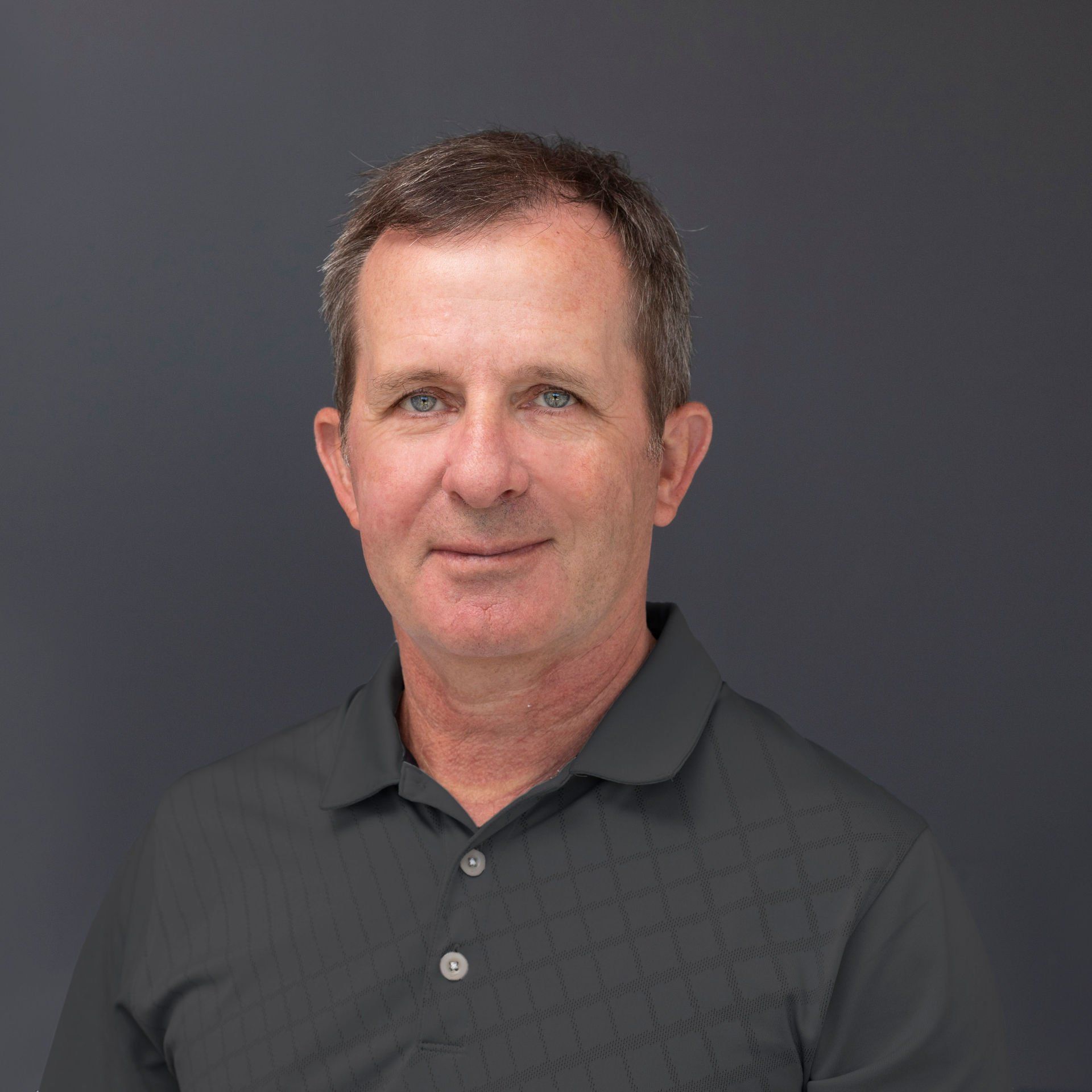 A man in a black shirt is smiling for the camera.