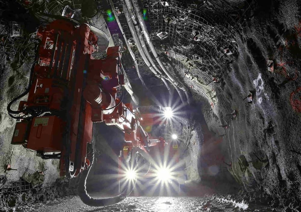 A Machine is Driving Down a Tunnel With Lights on — Secure Mine Solutions In Ryan, QLD