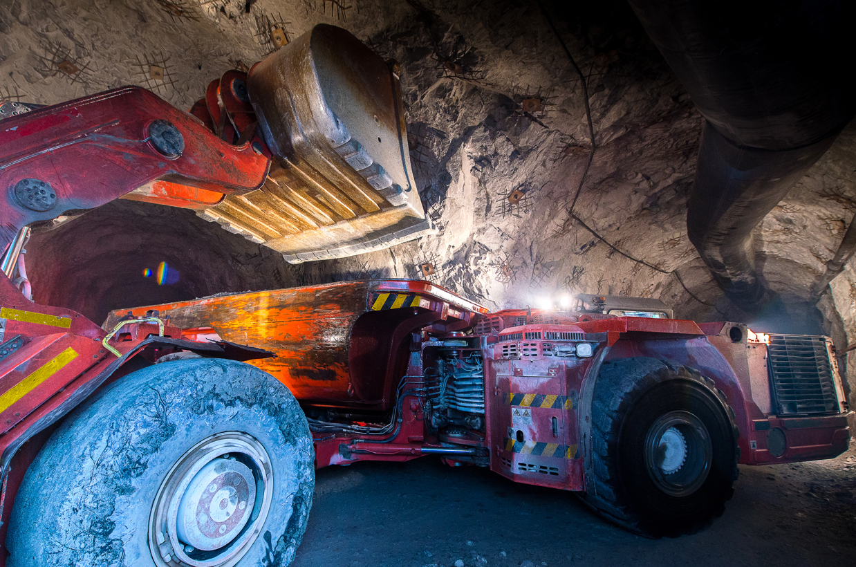 A Red Truck is Driving Down a Dirt Road in a Cave  — Secure Mine Solutions In  Ryan, QLD