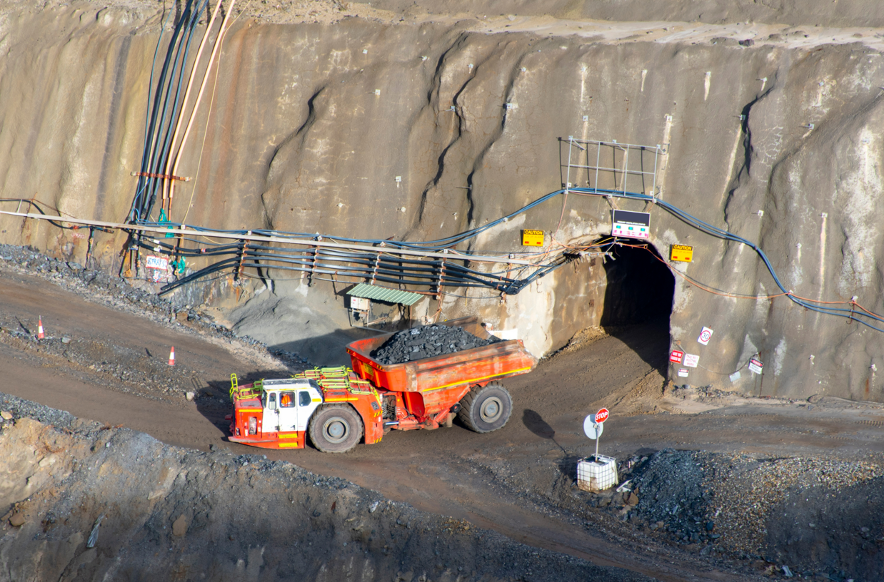 A Large Truck is Driving Through a Tunnel in a Mine  — Secure Mine Solutions In  Ryan, QLD