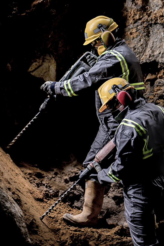 Two Men in Hard Hats Are Working in a Cave  — Secure Mine Solutions In  Ryan, QLD