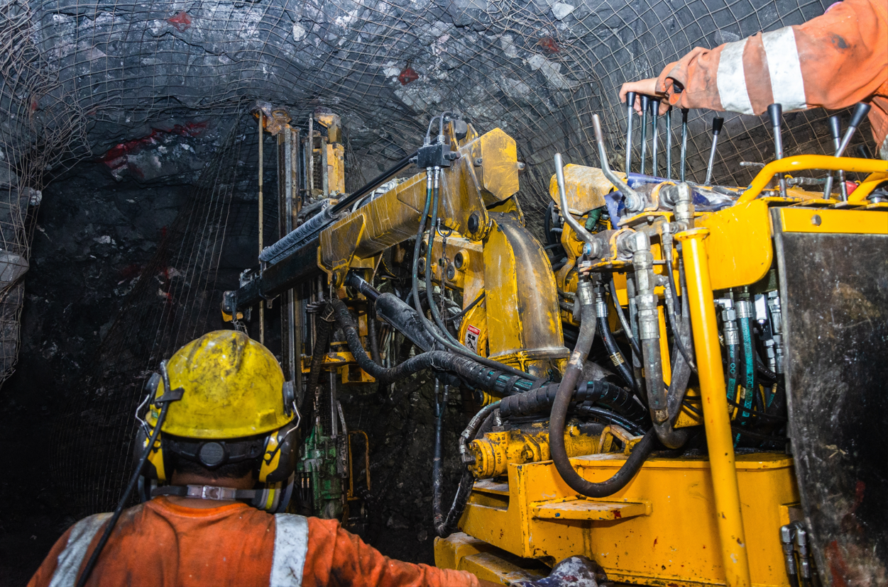 A Man is Working on a Machine in a Mine  — Secure Mine Solutions In  Ryan, QLD