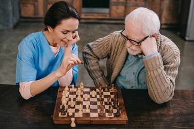 Elder Care — Nurse and Elder Man Playing Chess in Mt. Laurel, NJ